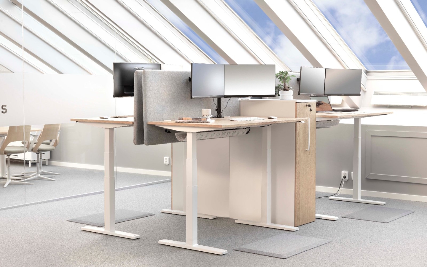 Kontorsmiljö med höj- och sänkbara skrivbord och ergonomiska ståmattor från Safety First